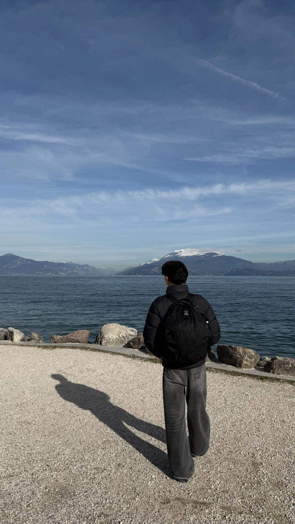 Looking across the lake in Sirmione, with a long shadow on the sunlit shore.